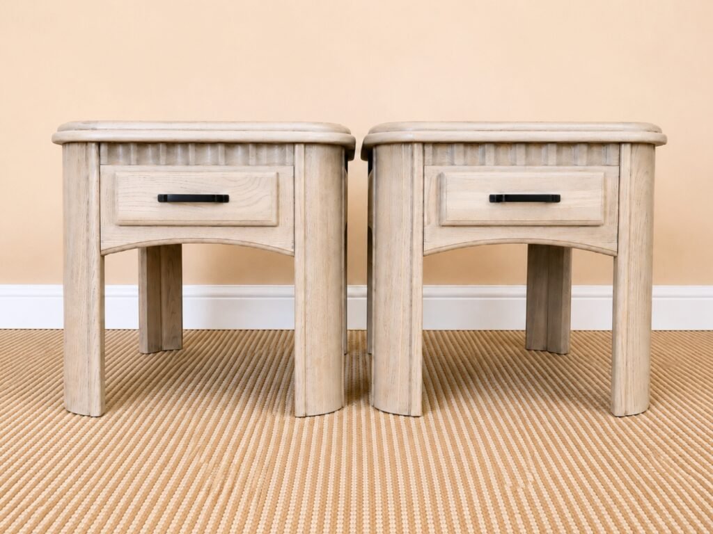 Matching solid wood end tables with light natural wood-wash finish, functional drawers, and matte black pulls.